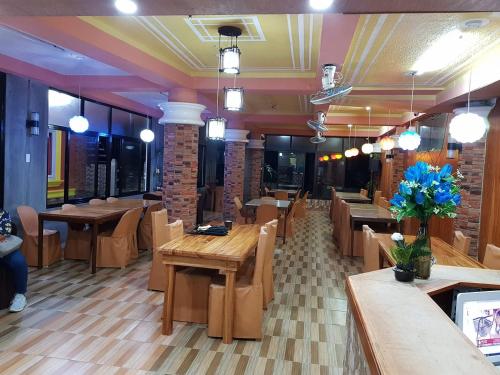 a dining room with wooden tables and chairs at Jun and Carol Beach Cottages in Pagudpud