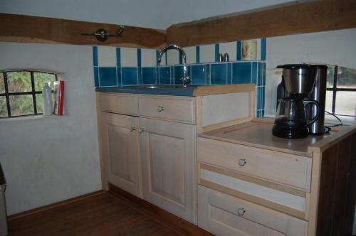 eine Küche mit einer Spüle und einem Mixer auf der Theke in der Unterkunft B&B Onze Deel in Hijken
