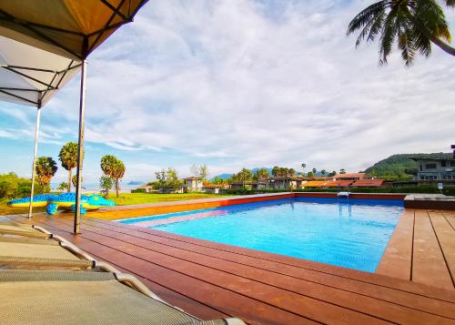 una piscina con terraza de madera junto a una casa en Anissa Resort Koh Yao Yai, en Ko Yao Yai