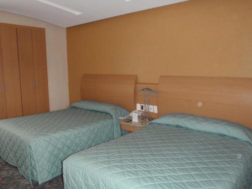 a hotel room with two beds in a room at Hotel Plaza Las Fuentes in Puebla