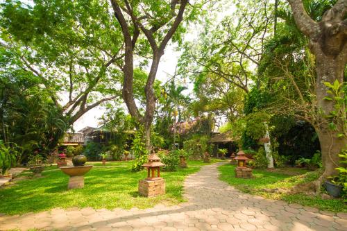a garden with trees and a walkway at Secret Garden Chiangmai in San Kamphaeng