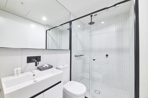 een badkamer met een douche, een toilet en een wastafel bij Mega Style Apartments The International in Melbourne