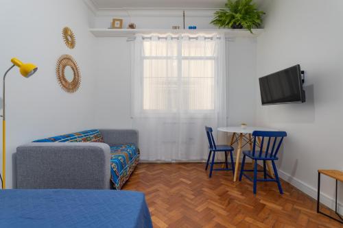 Una sala de estar con un sofá y sillas y una mesa. en Cafofo Nice, en Río de Janeiro