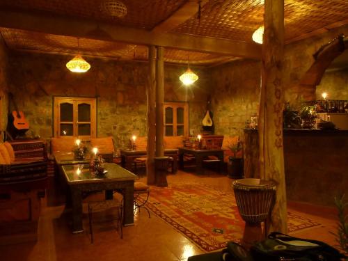 a living room with a table and chairs and candles at Auberge Le Festival Todra Gorge in Aït Baha