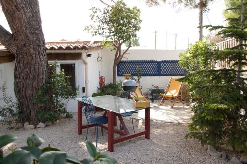 a patio with a table and chairs in a yard at Maison d'Hôte du Jas in Ensuès-la-Redonne