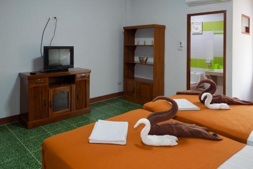 two swans on two beds in a room with a tv at Jardin in Pattaya South