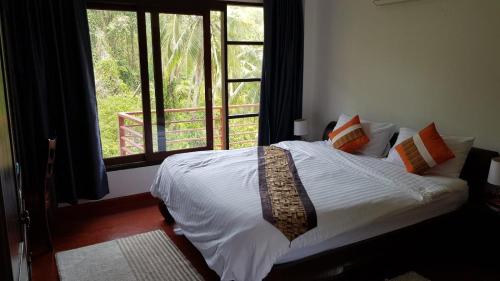 a bedroom with a bed and a large window at Spacious ocean view pool villa in Koh Samui