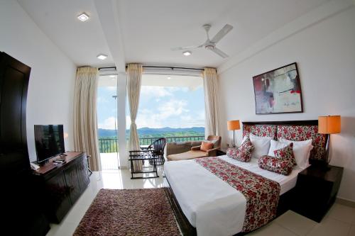 a hotel room with a bed and a large window at Romance Hills Hotel in Kandy