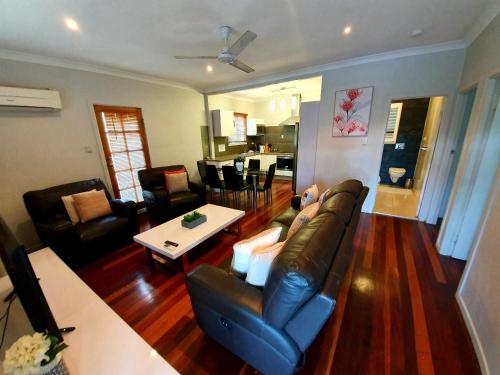uma sala de estar com um sofá e uma mesa em 2 bedroom cottage em Townsville