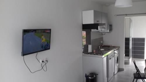 a kitchen with a tv hanging on the wall at perle rare à énergie positive in Saint-Michel-Chef-Chef