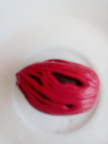 a piece of red yarn on a white plate at river edge bungalow in Matale