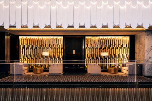 a lobby with tables and chairs and gold pipes at Bellagio by MGM Shanghai - on the bund in Shanghai