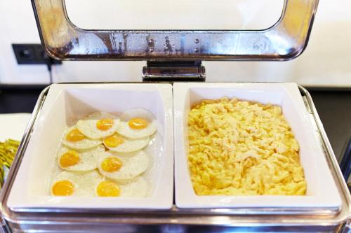 two white dishes of food with eggs and rice at Koszary Arche Hotel in Góra Kalwaria