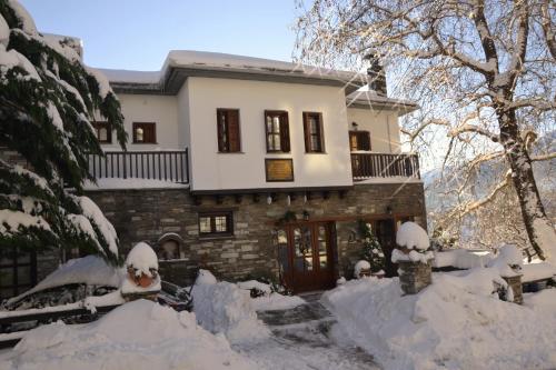 una casa está cubierta de nieve en Φιλυρέα - Ενοικιαζόμενα Δωμάτια, en Zagora