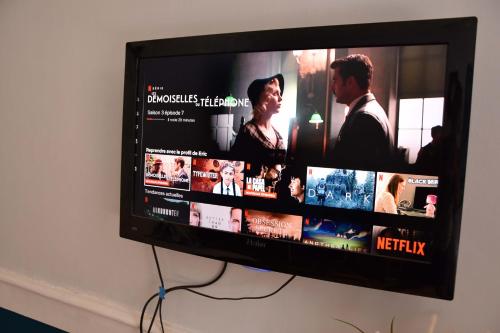 a flat screen tv hanging on a wall at Charmant Studio au calme à 5 min du centre ville in Saint-Claude