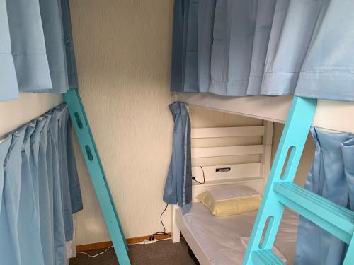 two bunk beds with blue doors in a room at Onsen & Garden -Asante Inn- in Hakone