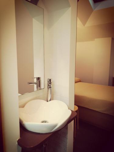 a bathroom with a white sink and a mirror at Pension Paloma - Oiartzun in Oiartzun