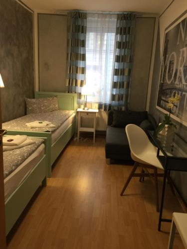 フュルトにあるIn Fürth wie Zuhauseのベッド1台とソファが備わる小さな客室です。