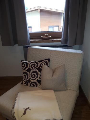a couch with pillows sitting in front of a window at Apart Tyrol in Uderns