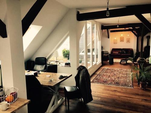 un salon avec une table et un canapé dans l'établissement Helle Dachgeschosswohnung für 8 Personen in zentraler Lage, à Berlin