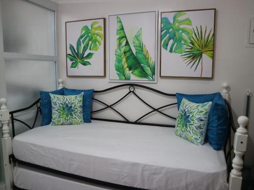 a bedroom with a bed with four pictures on the wall at Ohana at Tagaytay Prime in Tagaytay