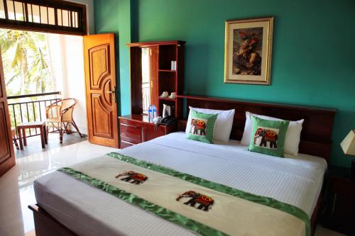 um quarto com uma cama grande e paredes verdes em Serenity Hill Oasis em Kandy