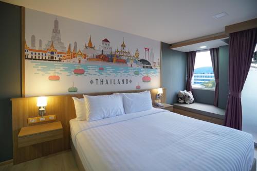 a hotel room with a bed and a mural on the wall at The Qube fifty Hotel in Bangkok