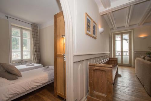 Cette chambre dispose d'un lit et d'une porte avec fenêtre. dans l'établissement Lutetia Apartment - Chamonix All Year, à Chamonix-Mont-Blanc