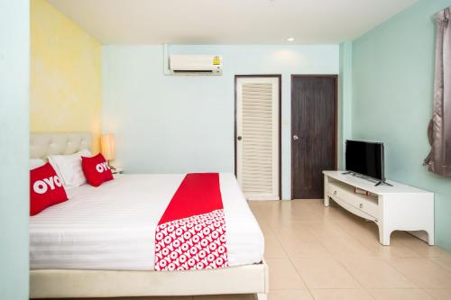 1 dormitorio con 1 cama y TV en OYO 345 The Click Guesthouse At Chalong, en Rawai Beach