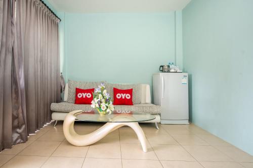 a living room with a couch and a table and a refrigerator at OYO 345 The Click Guesthouse At Chalong in Rawai Beach