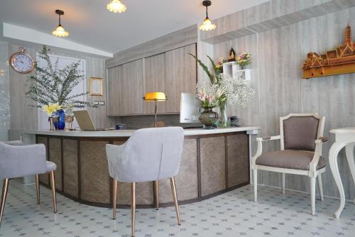 a kitchen with a counter with two chairs and a table at The Qube fifty Hotel in Bangkok