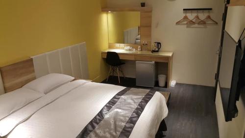 鹿港的住宿－頤園行館，一间卧室配有一张床和一张带镜子的书桌