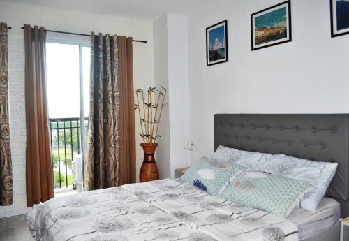 a bedroom with a bed and a window at Unit 1109 Cityscape Residences in Bacolod
