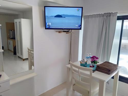 a living room with a tv on a wall at Amy's beach apartments in Rayong