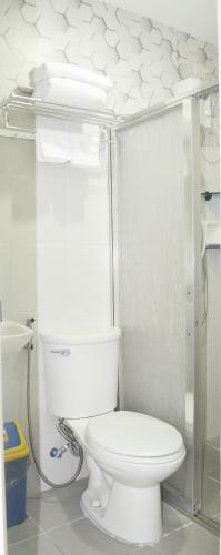 a white bathroom with a toilet and a shower at Unit 1109 Cityscape Residences in Bacolod