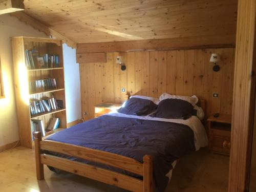 a bedroom with a bed in a room with wooden walls at Le chalet de Bernoline vaste appartement tout confort in Beaufort