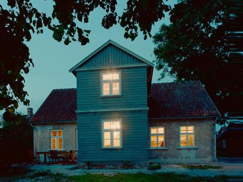 a house with its lights on in front of it at Kalnciema kvartāla Kuldīgas rezidence in Kuldīga