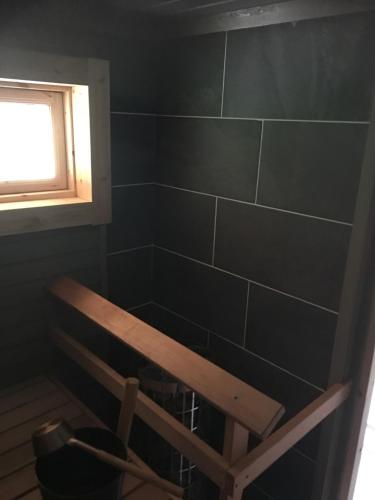 a bathroom with a bench and a window at Mökki in Söderkulla