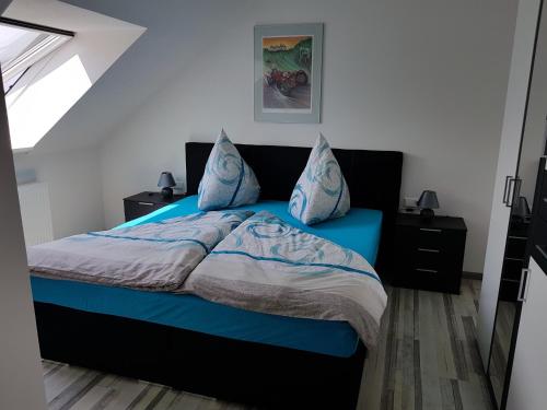 sypialnia z niebieskim łóżkiem i niebieskimi poduszkami w obiekcie Hohenlohe -Residenz-Svetlana w mieście Langenburg
