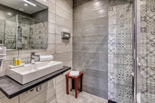 a bathroom with a sink and a shower at Cit'Hotel La Résidence in Nancy
