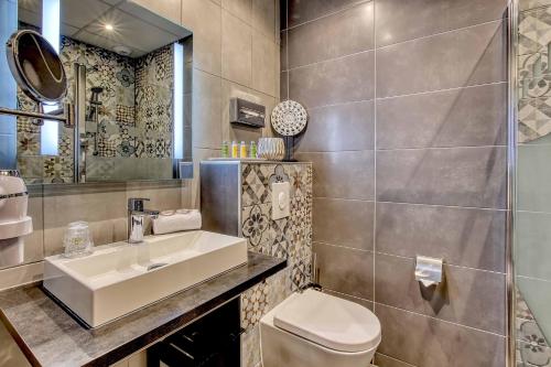 a bathroom with a sink and a toilet and a mirror at Cit'Hotel La Résidence in Nancy