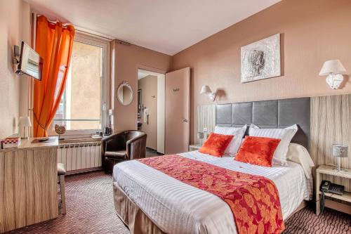 a hotel room with a large bed with red pillows at Cit'Hotel La Résidence in Nancy