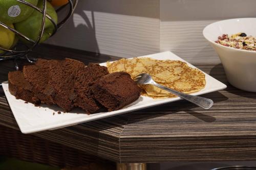 a plate of chocolate cake and chips on a table at Cit'Hotel La Résidence in Nancy