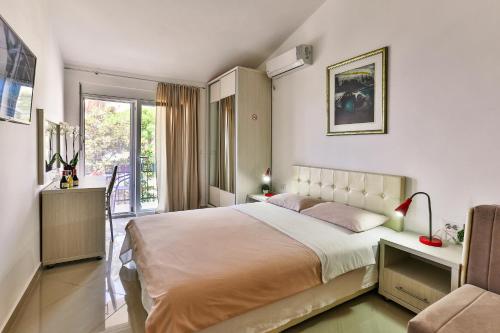 a bedroom with a bed and a table and a chair at Zelen LUX in Sutomore