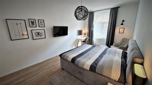 a bedroom with a bed and a couch and a window at Jacob´s Apartement in Plzeň
