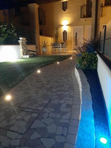 einen Hinterhof mit einem steinernen Gehweg in der Nacht mit Lichtern in der Unterkunft Sotto il Portico Home in Tezze sul Brenta