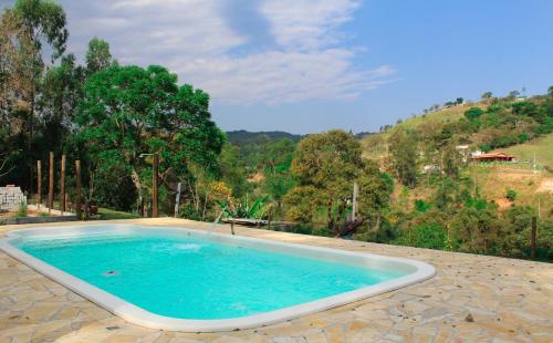 uma grande piscina no meio de uma montanha em Chalés Recanto Moinho em Toledo