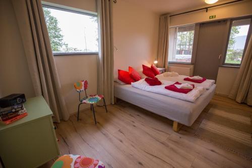 a bedroom with a large bed with red pillows at Hestasport Apartment in Varmahlid