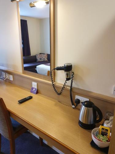 a light on a desk in a room with a mirror at Stables Inn, Aintree in Liverpool