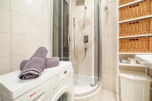 y baño con lavadora y ducha. en Dolce Warszawa CityCenter en Varsovia